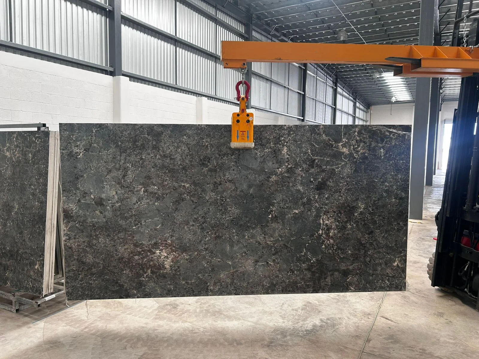 Maniobra de placa ultracompacta en bodega Petrium — importación directa Mérida